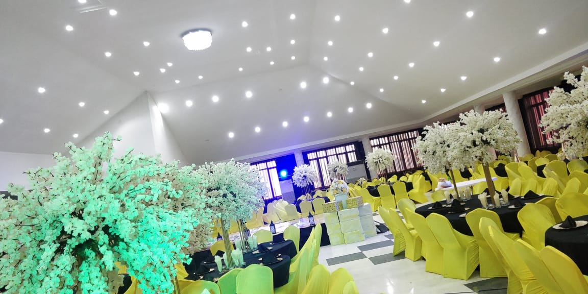 The hall dressed in yellow and black with blossom centerpieces