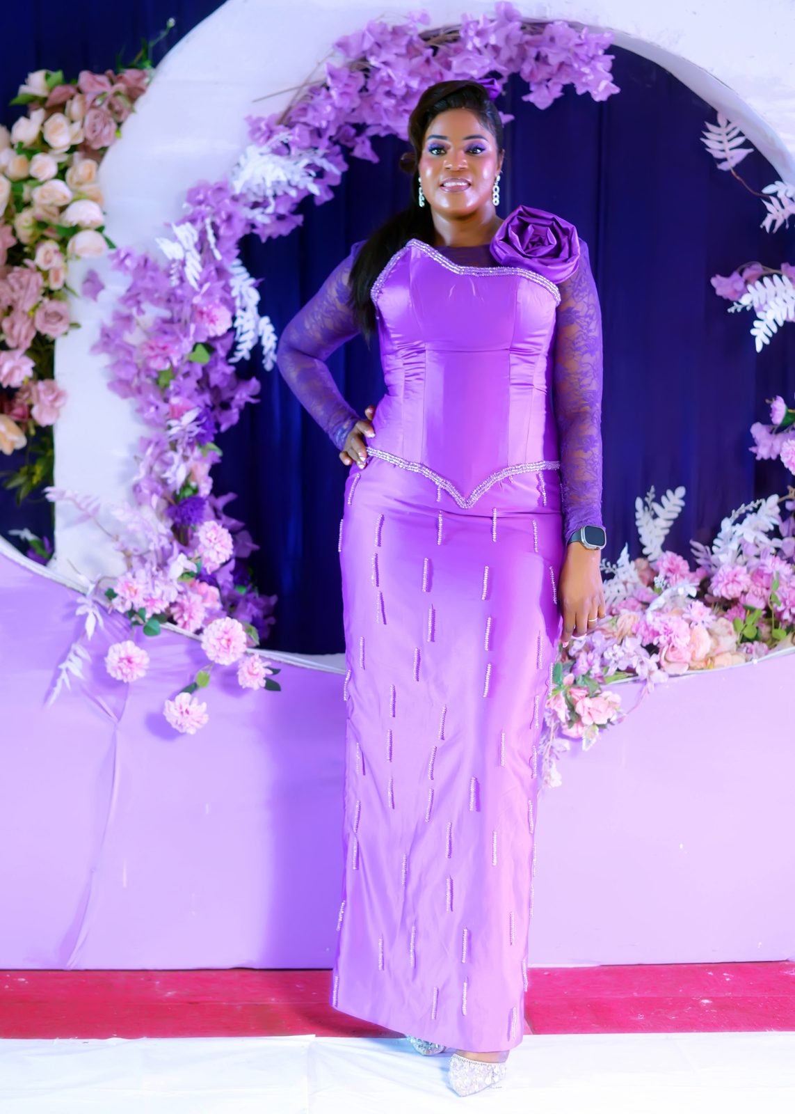 A guest in a fitted lilac gown at the arch