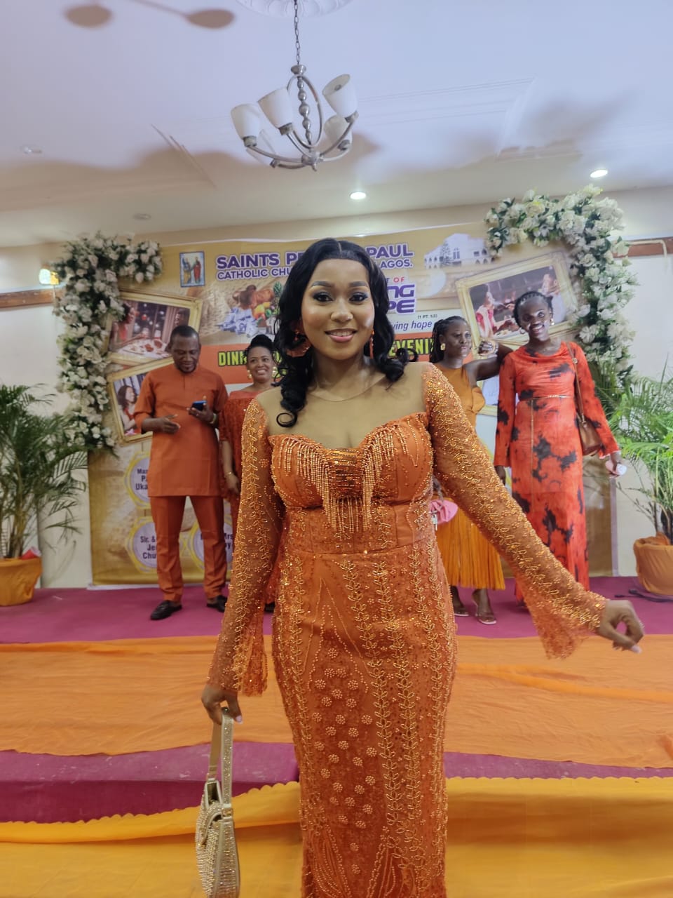 A guest arriving in terracotta lace at the church backdrop