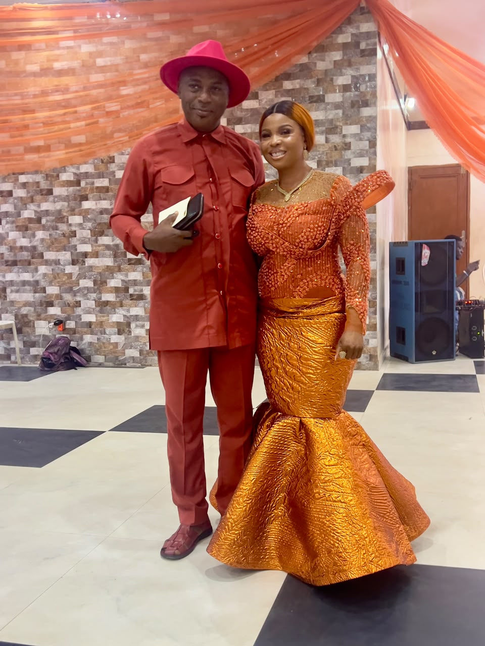 A couple dressed in rich terracotta and gold at the dinner
