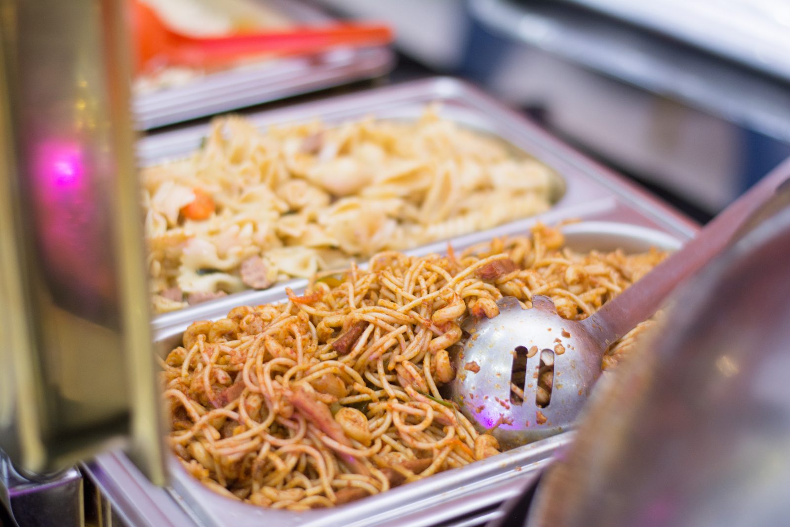 Chafing dishes of jollof, noodles and more along the buffet