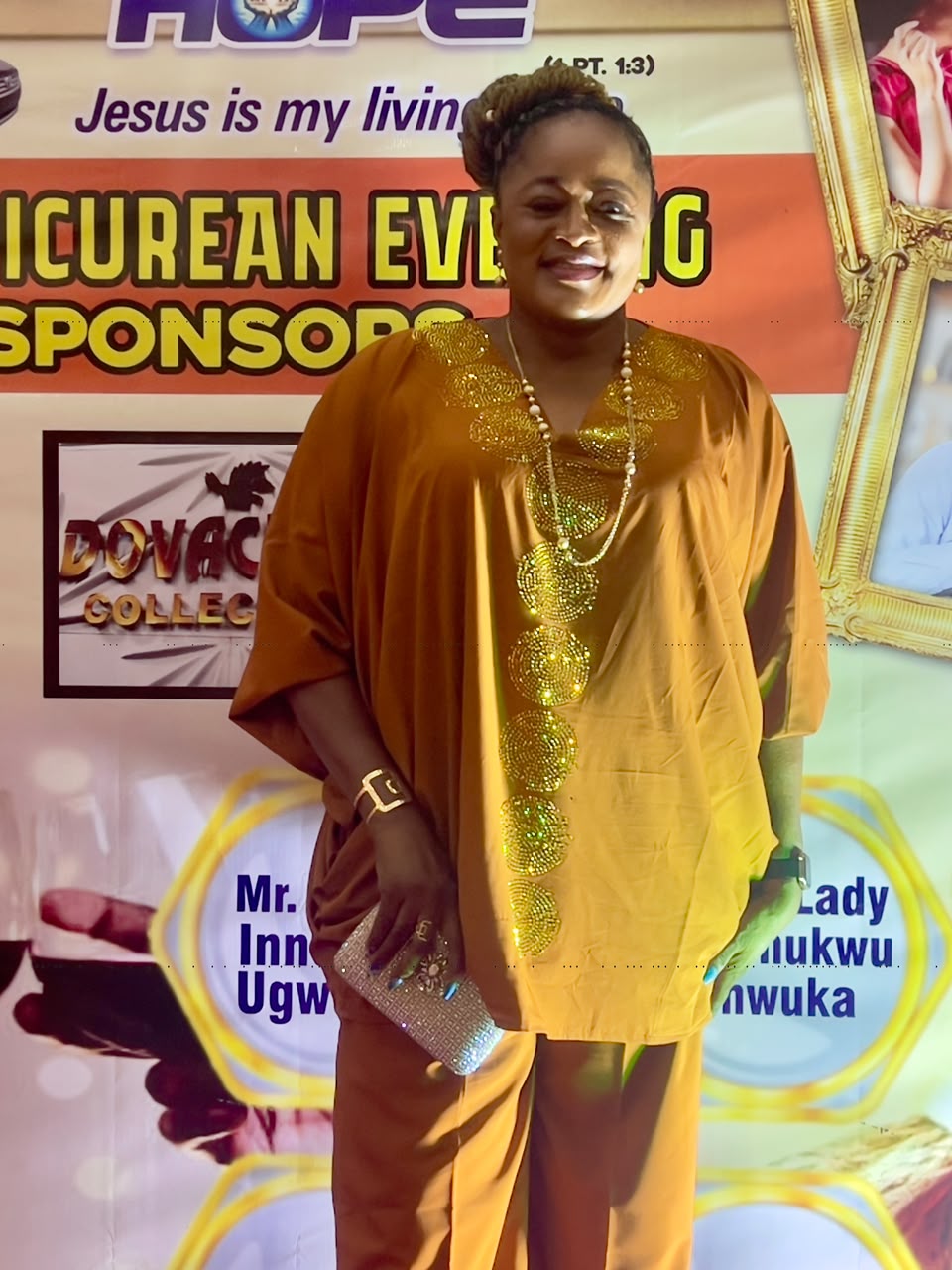 A guest in a gold outfit at the sponsors backdrop