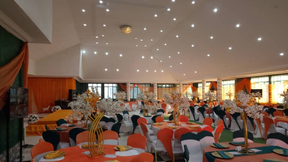 The banquet hall dressed in orange and gold, tables set for guests